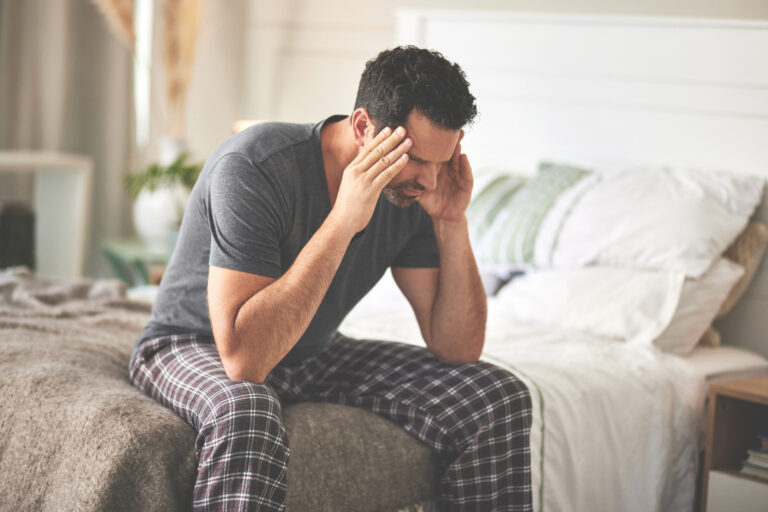 Erectyle dysfunction - frustrated man sitting in bed